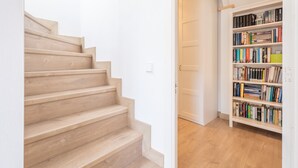 Un escalier menant à une pièce où se trouve une bibliothèque remplie de livres.