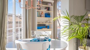 Une table ronde blanche, avec des chaises, une nappe bleue et des verres à vin vides.