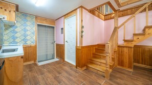 A wooden staircase leading to an upper floor, a bathroom with a shower, and a tiled wall. - Yeongheungdo Blue Story Pension (Incheon)