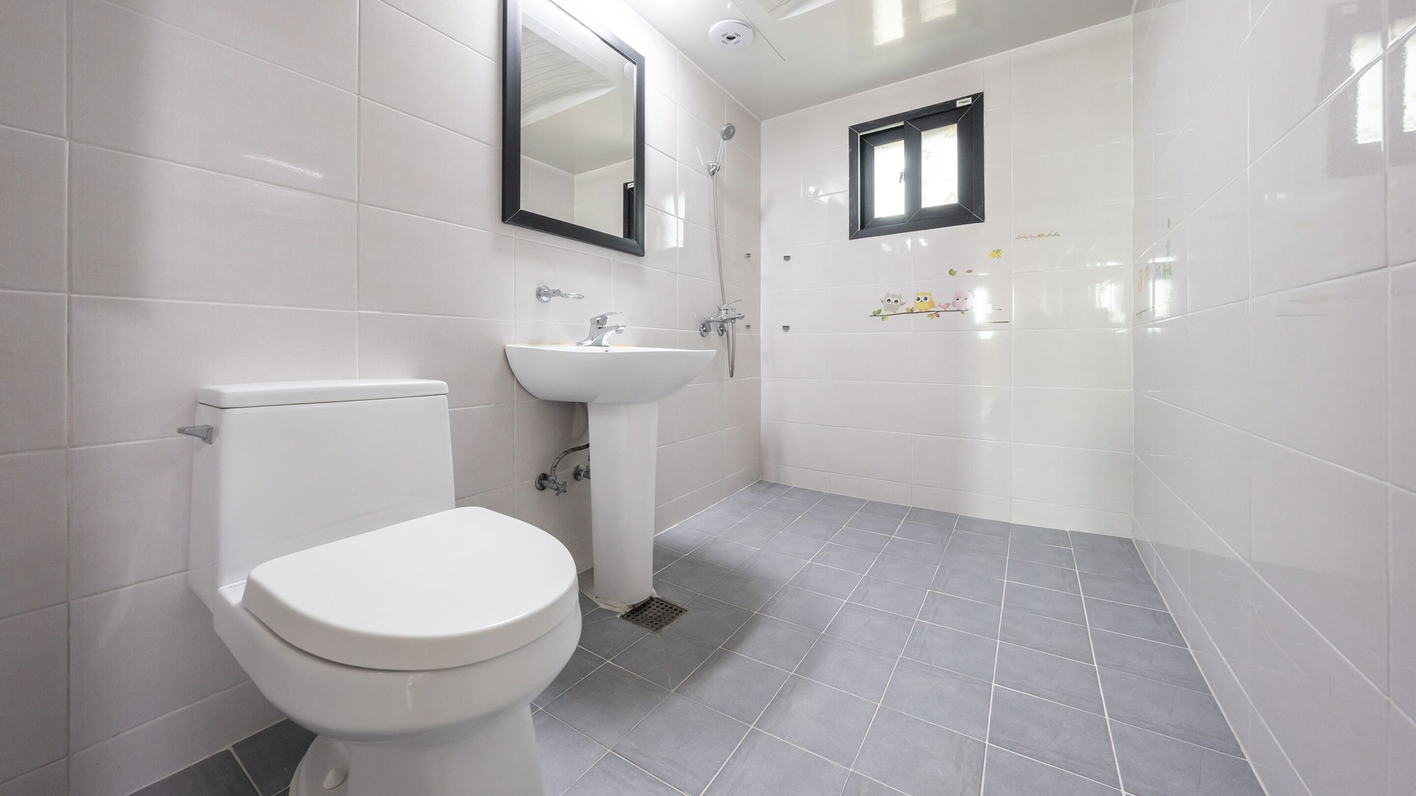 A bathroom with a toilet, sink, and shower.