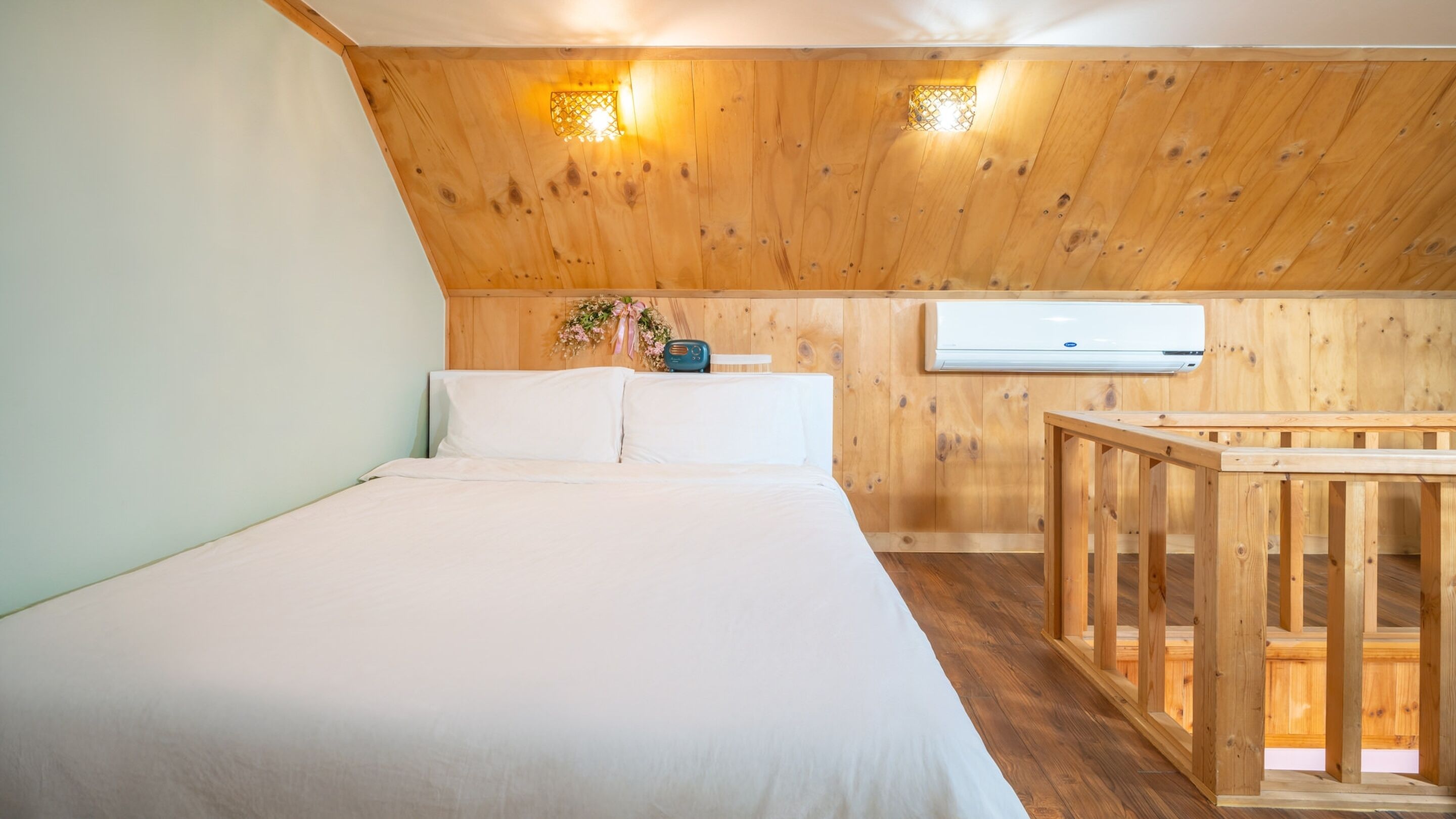 A bedroom with a wooden ceiling, a bed, a nightstand, and a small table.
