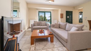 Un salon avec une cheminée, deux canapés, une table basse et un ventilateur de plafond.
