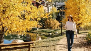 A person walking on a dirt path surrounded by yellow autumn trees, with a building in the background. - 8 Mins to Trails | Near Shuttle (Winter Park)