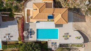 An aerial view of a modern house with a swimming pool, outdoor seating, and a patio area. - Villa Dinos with swimming pool (Kefallonia)