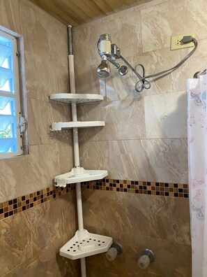 Een douche, handdoeken, shampoo, toiletpapier