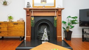 Ein Wohnzimmer mit Kamin, einem Couchtisch aus Holz und einem Fernseher.