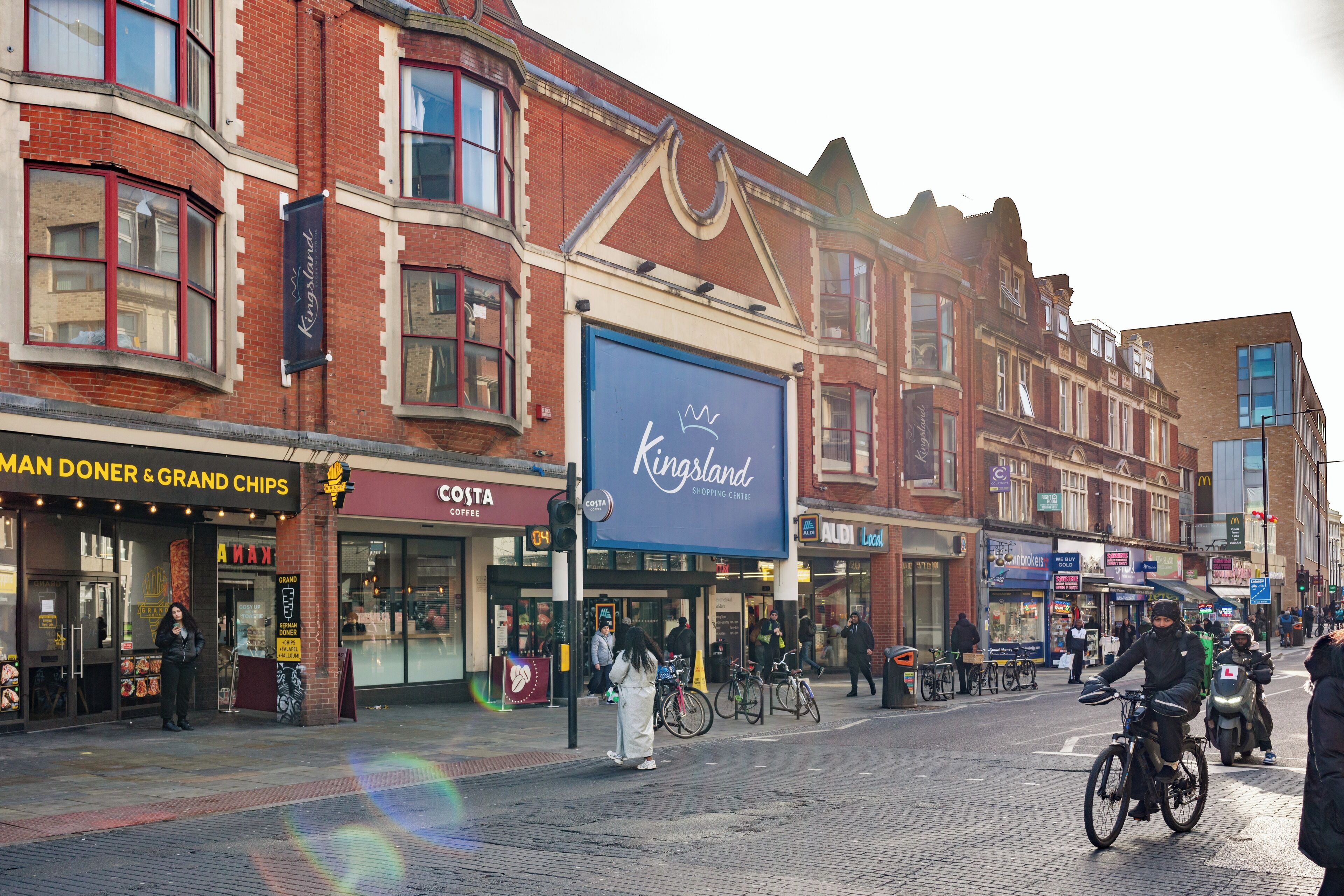 A street with shops, including a Kingsland shopping center and a Costa Coffee.