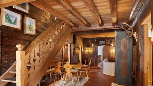 Un interior rústico con una escalera de madera, una zona de comedor y un sofá.
