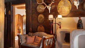 A rustic interior with a wooden sofa, antler wall decor, and a lamp. - Room '05 Mühlfeldhof A1' with Mountain View, Shared Terrace and Wi-Fi (Kelchsau)