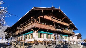 A traditional wooden building with multiple balconies and a steep roof, likely a mountain lodge or guesthouse. - Room '05 Mühlfeldhof A1' with Mountain View, Shared Terrace and Wi-Fi (Kelchsau)