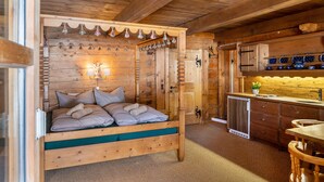 L’intérieur d’une cabane en bois comprend un lit, une petite cuisine et un coin repas.