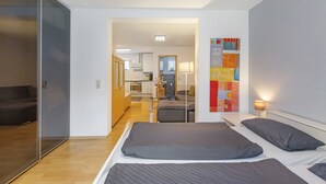 Una habitación de hotel moderna con una cama grande, un escritorio y vistas al área de la cocina.