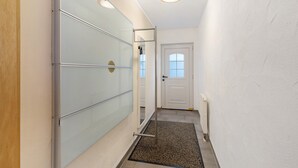 Un pasillo con un panel de vidrio, una puerta y un radiador.