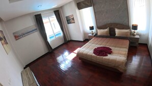 A hotel room with a large bed, a nightstand, a lamp, and a painting on the wall. - Beautiful pool villa 200 meters from the beach and the beach promenade 4 bedrooms (Bang Saray)