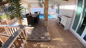 A covered outdoor area with a pool, a dining table with chairs, and a cabinet. - Beautiful pool villa 200 meters from the beach and the beach promenade 4 bedrooms (Bang Saray)