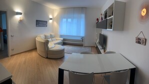 Un salon moderne avec un canapé, une table à manger et un téléviseur.