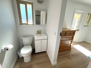 Une salle de bain avec des toilettes, un lavabo et un meuble en bois.