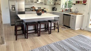 A modern kitchen with a central island, bar stools, and a dishwasher. - Apple Farm Paradise in Julian (Julian)