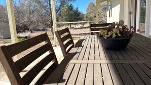 A wooden patio with two benches and a potted plant. - Apple Farm Paradise in Julian (Julian)