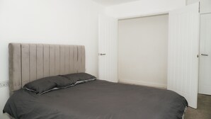 Ein Schlafzimmer mit einem Bett, einem Kopfteil und einem Schrank.