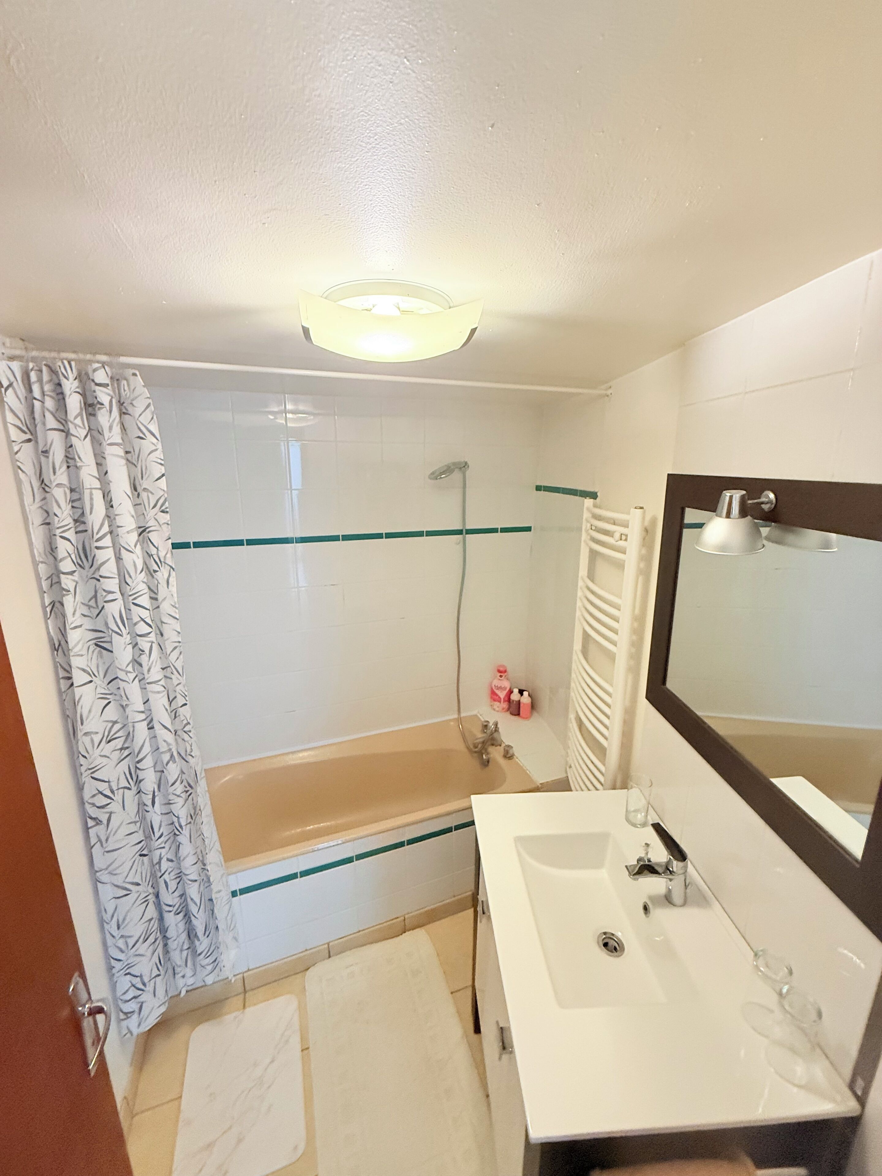 Un bagno con vasca, lavandino, specchio e doccia.