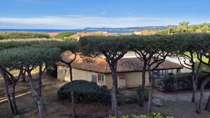 A Mediterranean-style villa with a terracotta roof, surrounded by mature trees and a view of the sea. - Swimming pool, air conditioning, 200 m from beaches, ideal for family holidays (SIX FOURS LES PLAGES)