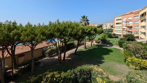 A hotel courtyard with a pool, trees, and a well-maintained lawn. - Swimming pool, air conditioning, 200 m from beaches, ideal for family holidays (SIX FOURS LES PLAGES)