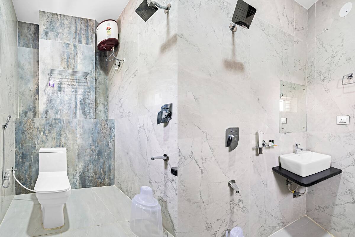 A modern bathroom with a toilet, shower, and sink.