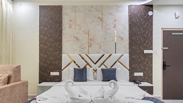 Habitació d'hotel amb un llit, una nitzeta, una cadira i una porta.