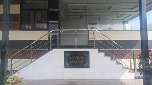 Un escalier menant à l’entrée d’un bâtiment, sur lequel on peut lire l’inscription : « PUSHKAR S.R. RESORT ».