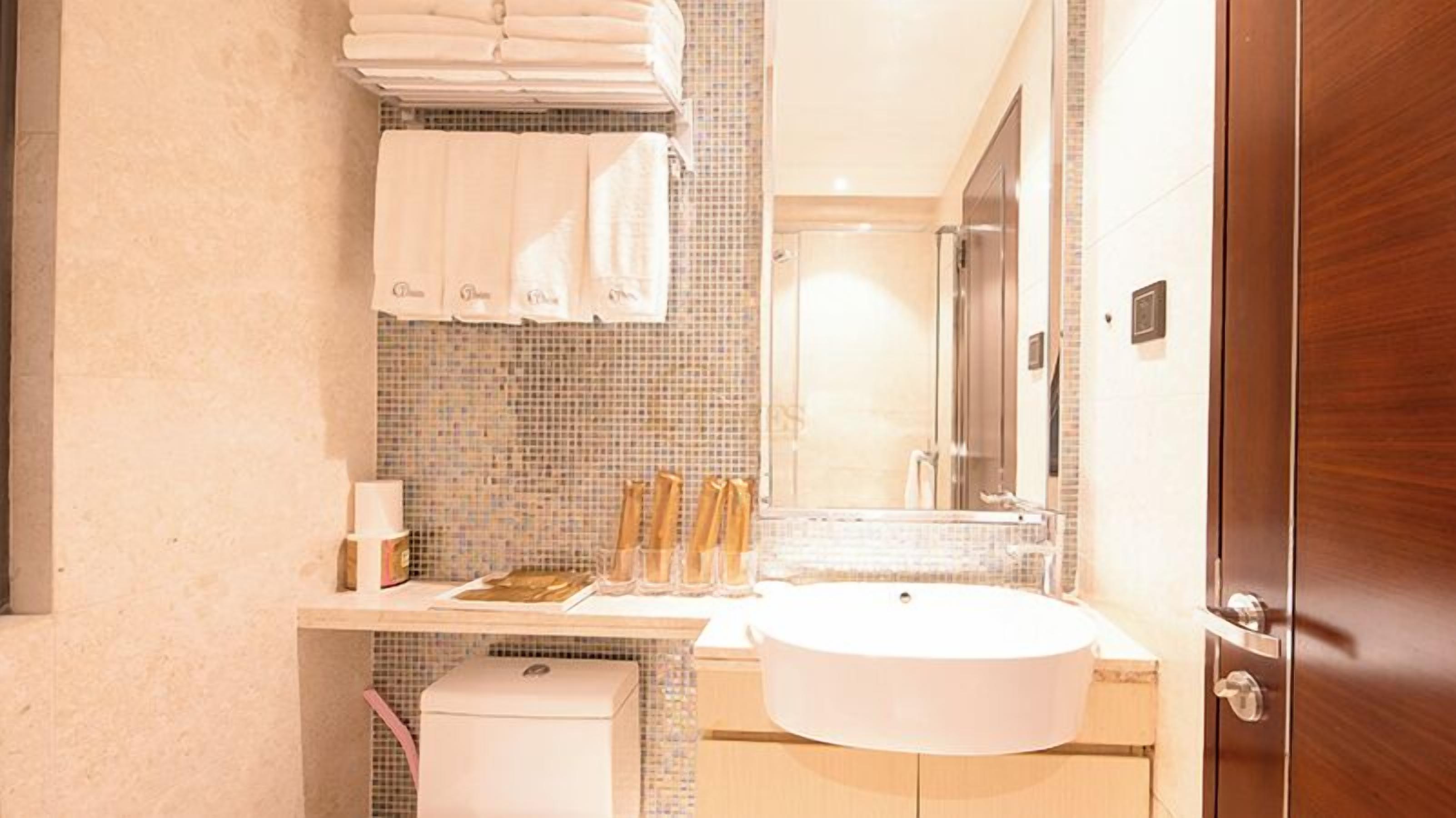 A bathroom with a sink, mirror, and towel rack.