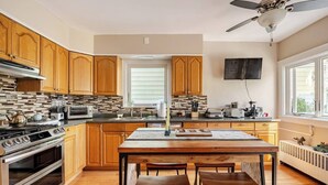 Una cocina moderna con armarios de madera, una isla central y un comedor con dos sillas.
