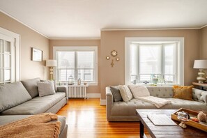 Un salon avec deux canapés, une table basse et un radiateur.