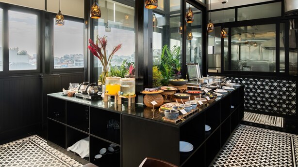 A modern breakfast bar with a variety of food items and a view of the city. - Bliss Signature Hotel (Hanoi)