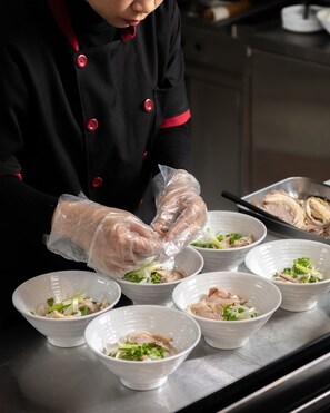 Ein Koch bereitet Essen in einer professionellen Küche zu.