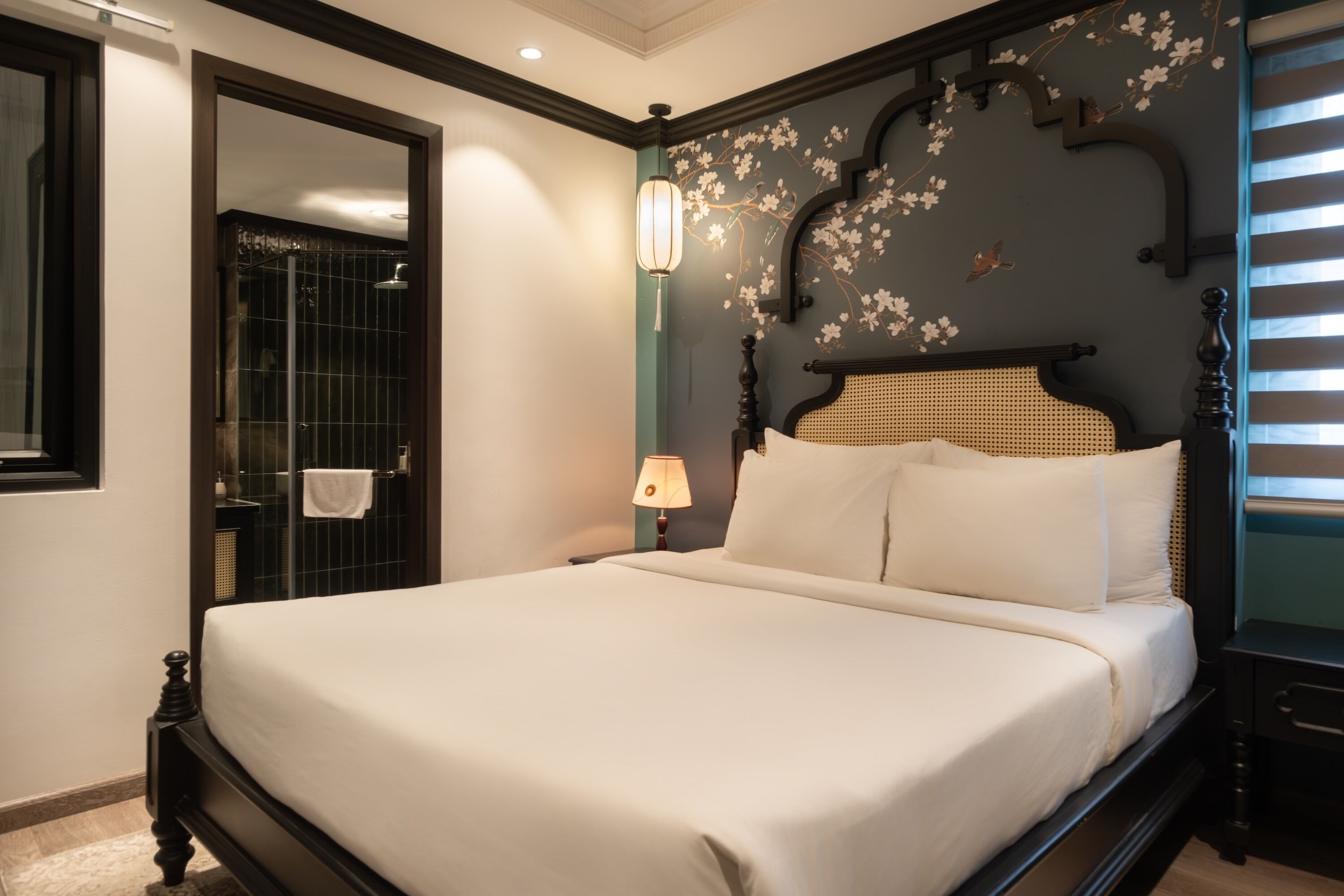 Une chambre d’hôtel avec un grand lit, une lampe de chevet, un miroir et un espace douche.