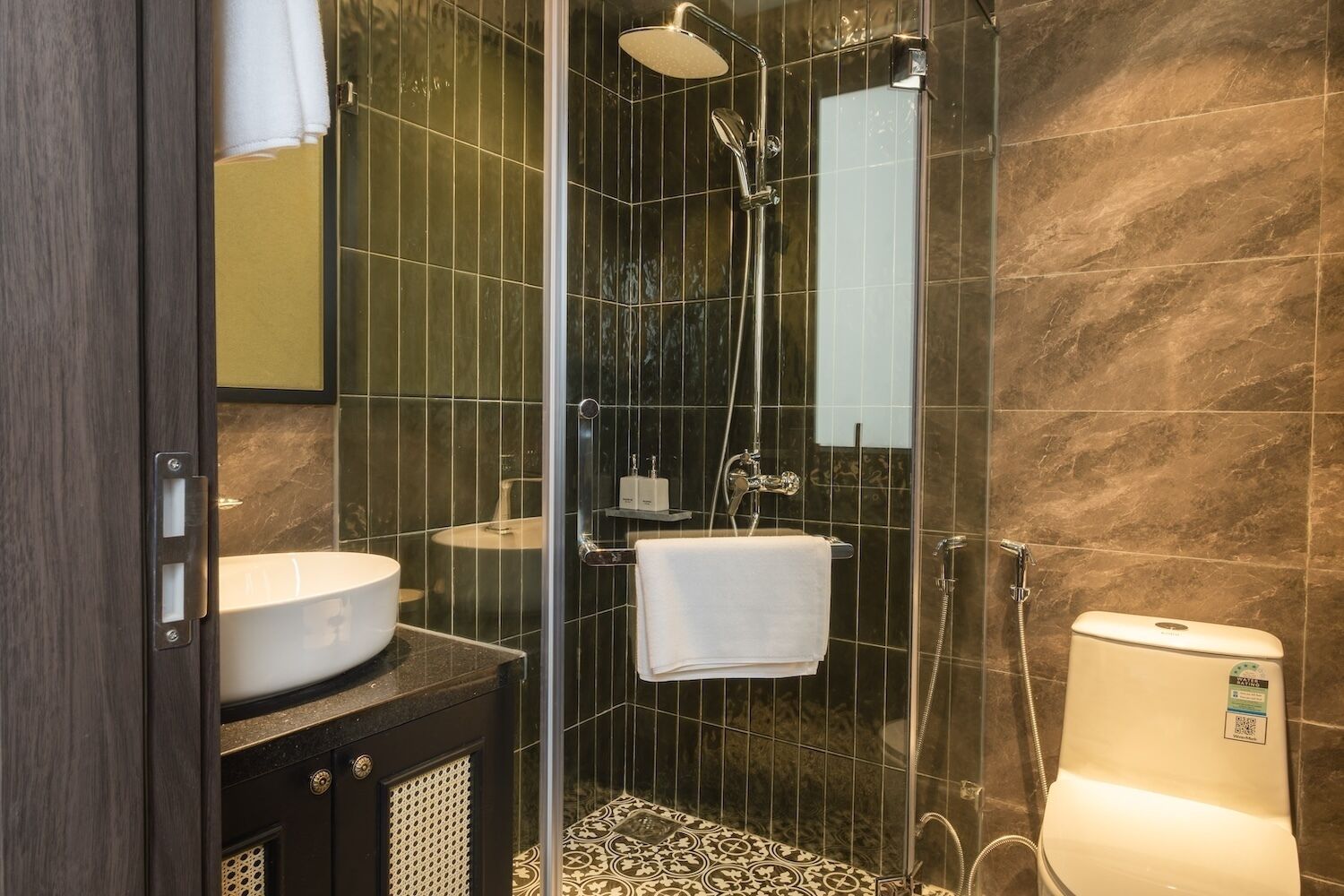 A modern bathroom with a glass-enclosed shower, a white sink, and a toilet.