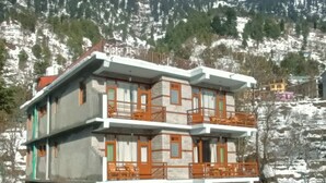 A multi-story building with balconies, a car parked in front, and snow on the ground. - Hotel Nayra Manali (Manali)