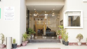 A hotel entrance with a glass door, potted plants, and a sign indicating no smoking and CCTV surveillance. - Five Elements Hotel Haridwar (Haridwar)