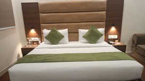 A hotel room with a large bed, two bedside tables, a nightstand, and a desk with a chair. - Five Elements Hotel Haridwar (Haridwar)