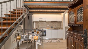 Eine moderne Küche mit Essbereich, einer Holztreppe und einer Kücheninsel.