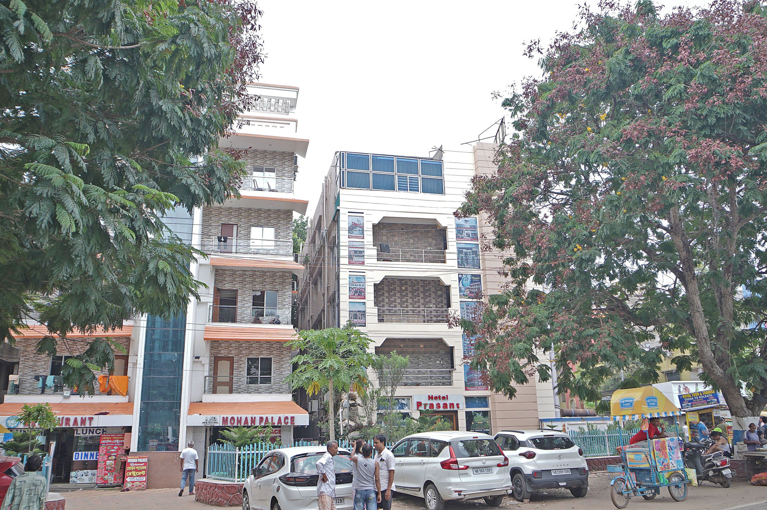 A multi-story hotel with balconies, a restaurant, and a visible sign for 'Hotel Presant'.