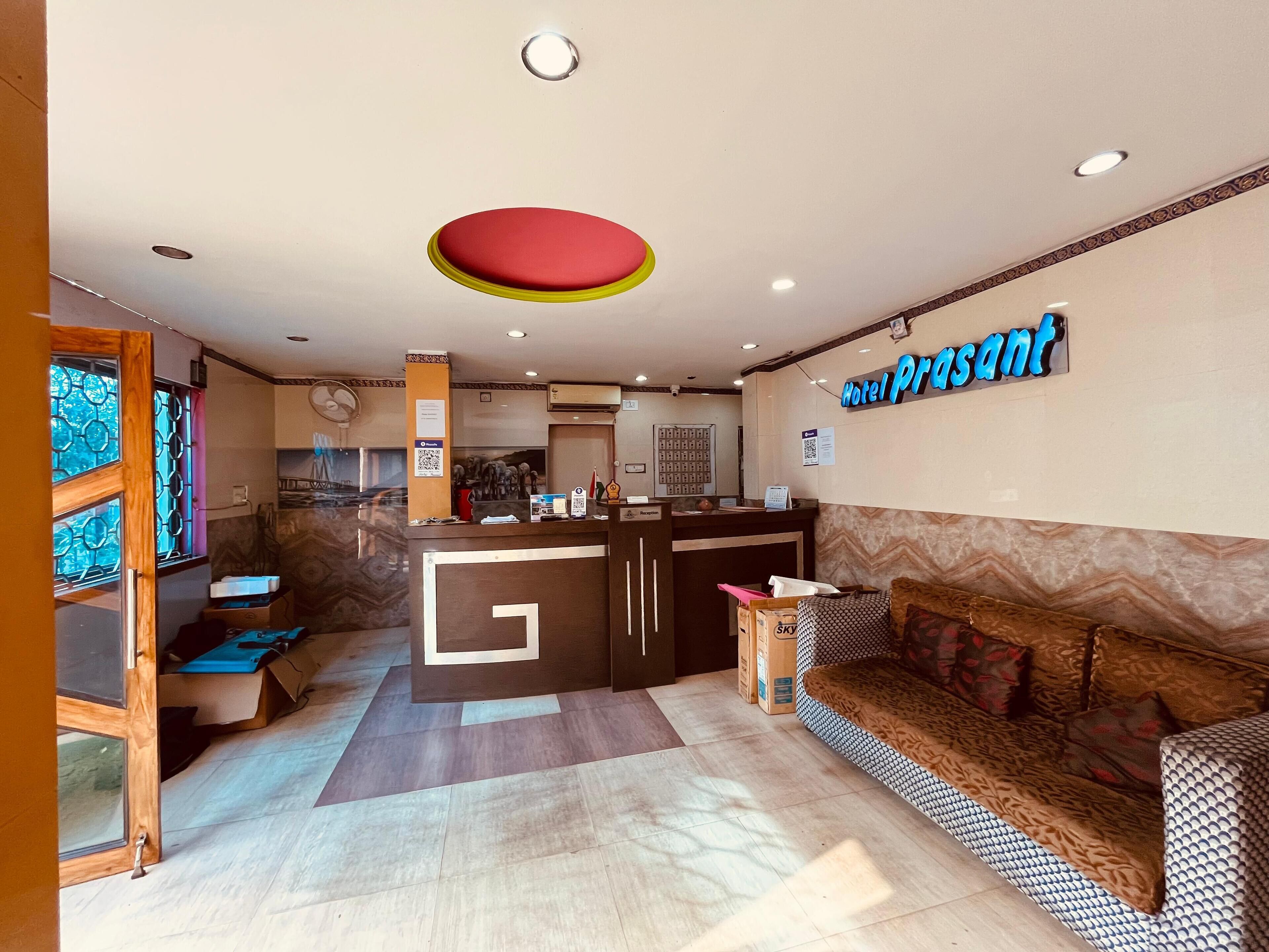 A hotel lobby with a reception desk, a sofa, and a patterned wall.