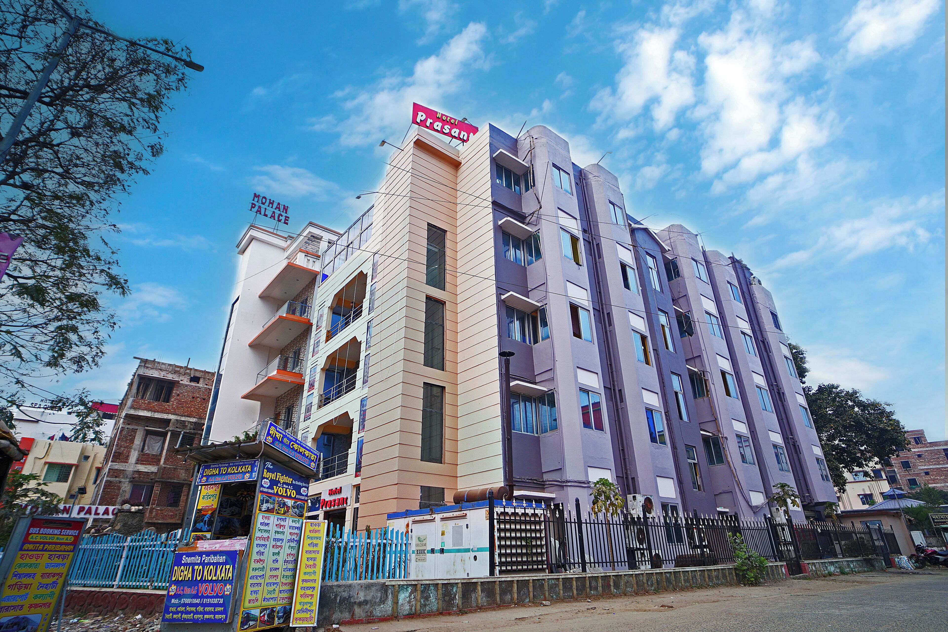 A multi-story hotel with a sign for "Hotel Prasan" and "Mohan Palace."