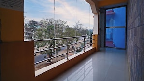 A hotel corridor with a large window offering a view of the street and trees.