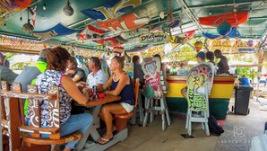 Un bar installé sur un bateau, avec des sièges en bois et un intérieur coloré et décoré.