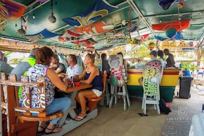 Un bar en un barco con asientos de madera y un interior colorido y decorado.