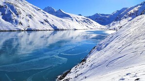 A snow-covered mountain landscape with a clear blue lake reflecting the sky. - Mountain Stay With Balcony (Saas Grund)