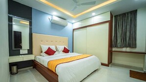 Una camera d'albergo moderna con un letto grande, un comodino, uno specchio e un armadio.