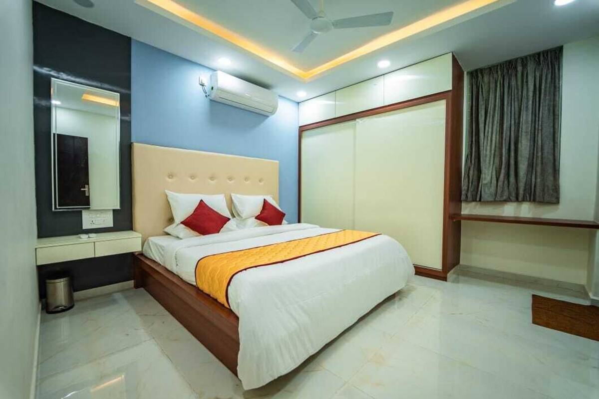 Une chambre d’hôtel moderne avec un grand lit, une table de chevet, un miroir et une armoire.